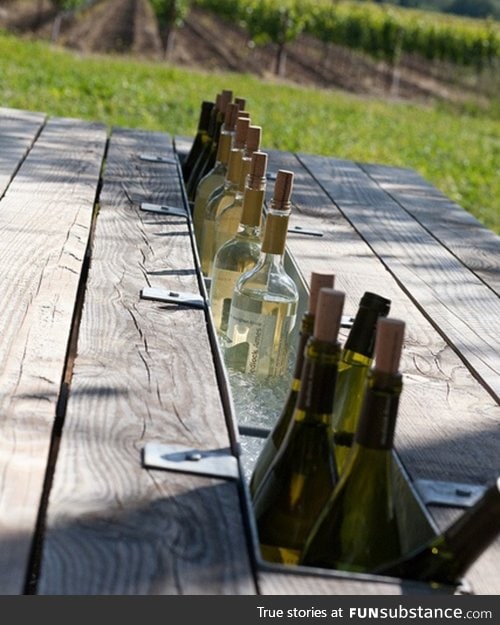 Some genius swapped the middle board of this table with a gutter to make a table top bar!