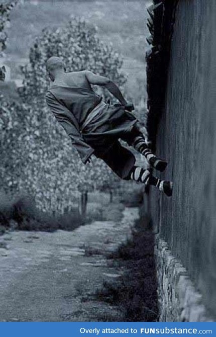 A shaolin monk running on a wall