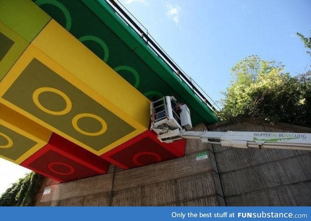 A crew in Germany painting a train bridge overpass to look like Lego blocks