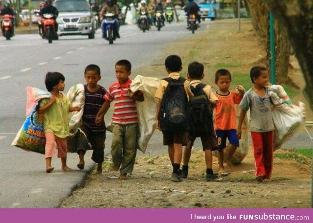 School boys passing by working boys in the Philippines