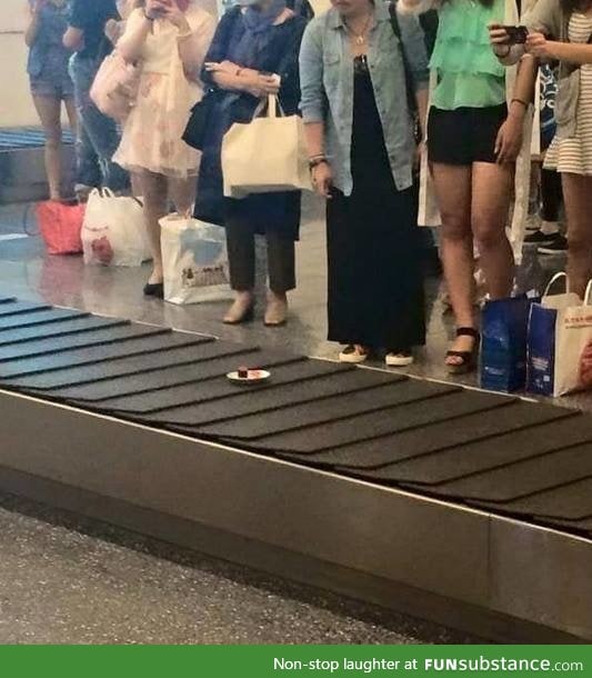 There is a sushi track plate on an airport luggage conveyor belt