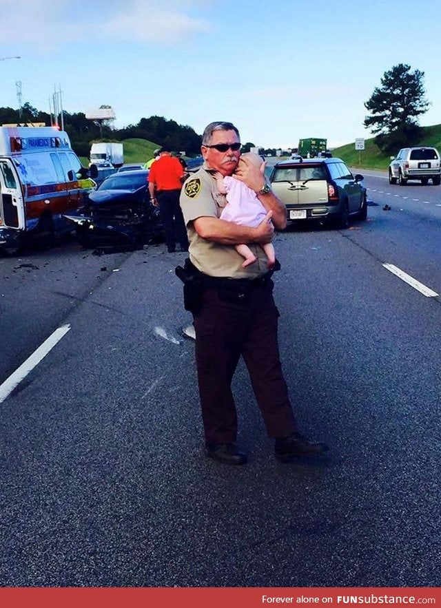 Officer comforts infant after multi-car crash