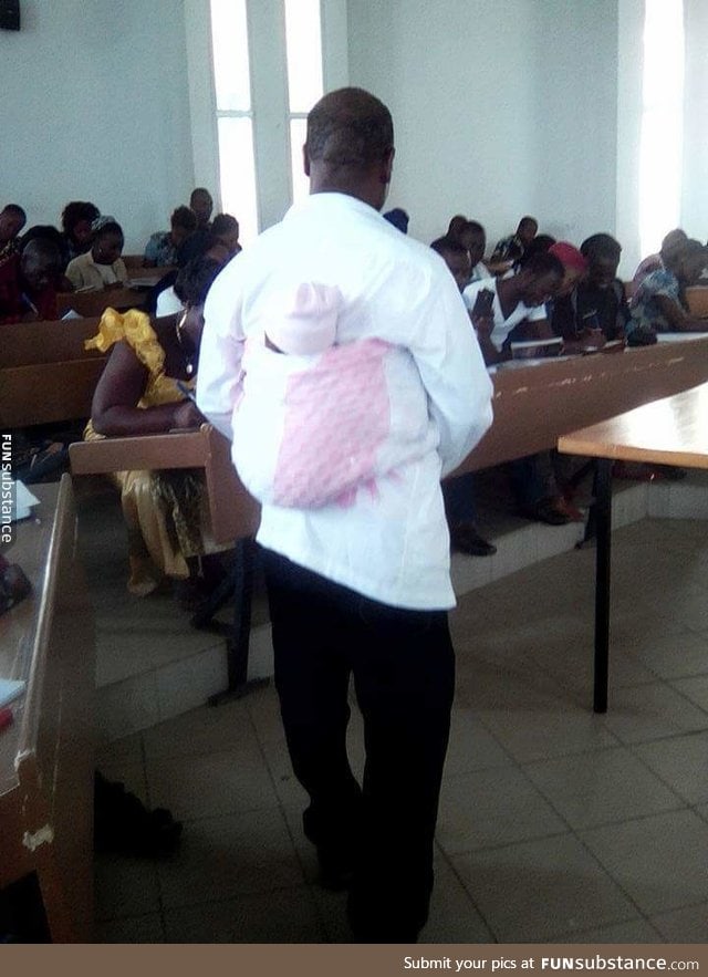 A college professor carries his student's child so she can sit her exams