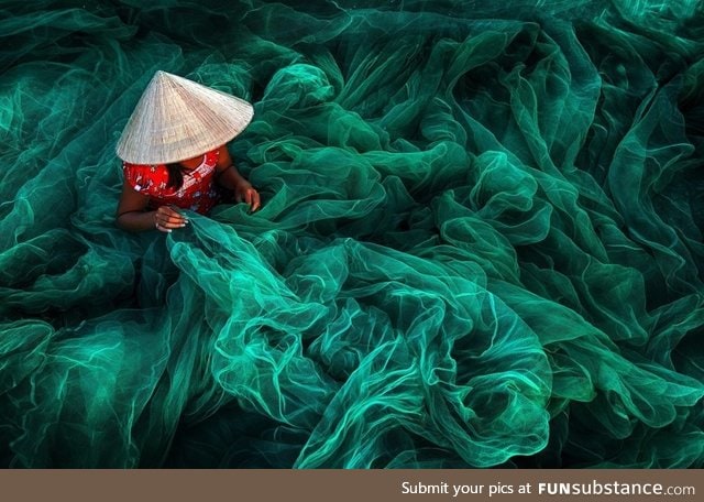 A woman creates a fishing net in a small village near Phan Rang