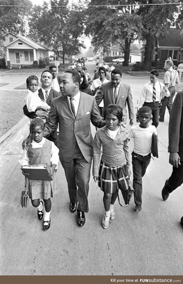 Martin Luther King Jr. escorting children to their newly desegregated school, 1966