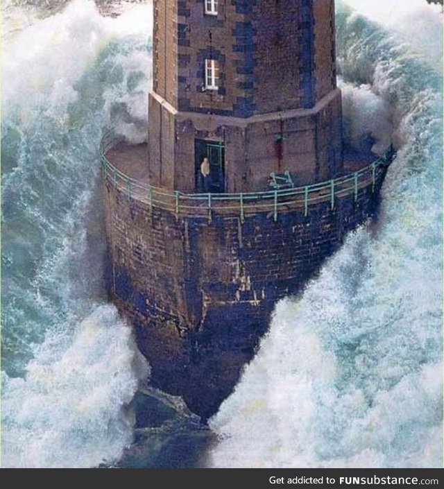 A massive wave hits a lighthouse off the coast of France