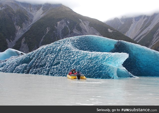 The dark blue bottom of an iceberg that just rolled over