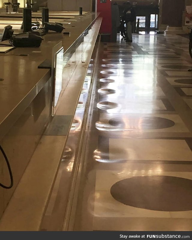 The marble floor of this bank has been worn away from decades of people standing in the