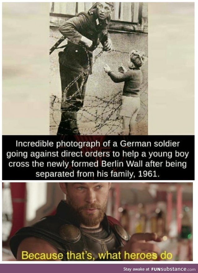 East German soldier helps a little boy sneak across the Berlin Wall, 1961