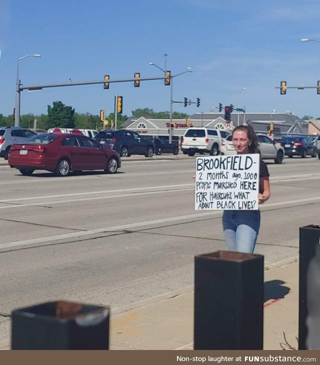 Young woman at Wisconsin protest calls out her city with this sign