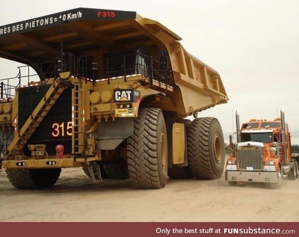 A big truck next to a really big truck