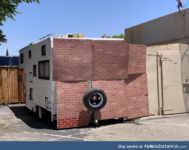 Move along, nothing to see here. Just a spare tire hanging on a brick wall