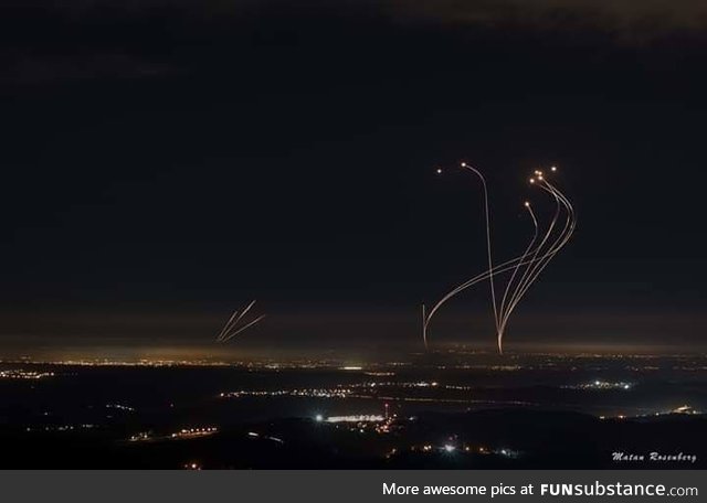 Rockets shot from Gaza (left) are met with intercepting rockets from the Iron Dome