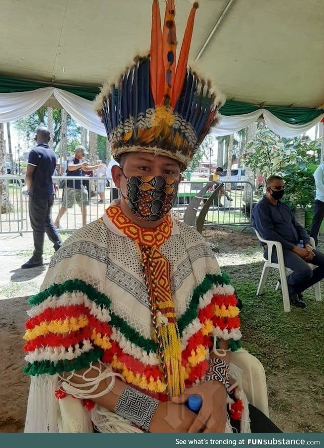 Indigenous man with face mask matching his beautiful traditional attire