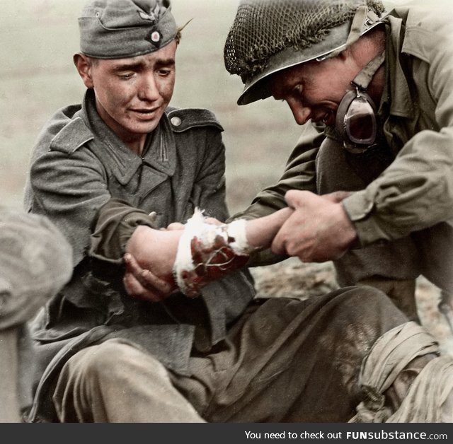 An American GI tending to a wounded young German soldier - France, Sept. 6 1944