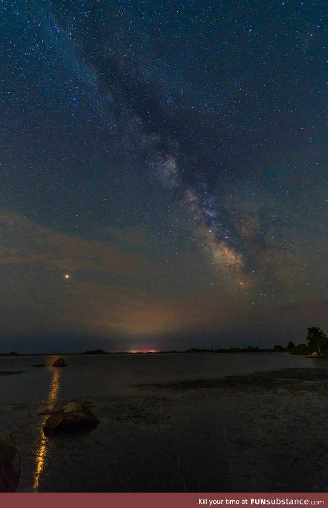 Mars casting its reflection in an ocean as it rises