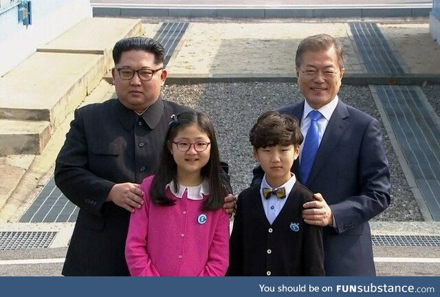 Korean gay couple celebrates their marriage with a family photo, circa. 2017