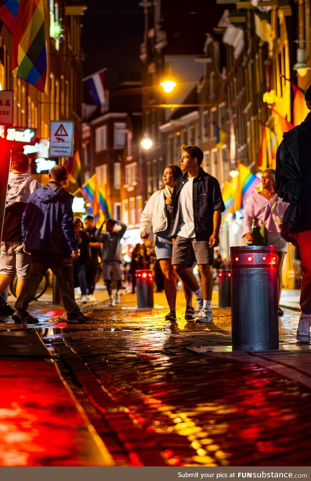 A couple exploring Amsterdam's Red Light District during Pride