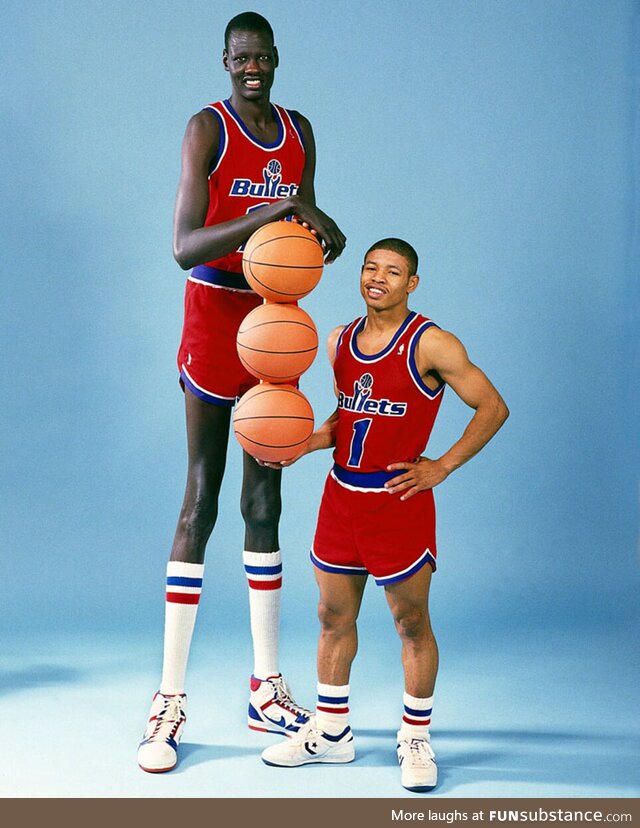 Manute Bol (7'6) standing next to his teammate, Muggsy Bogues (5'3)