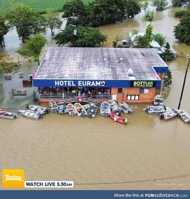 Floods in Cairns, QLD, Australia. Locals still attend the local pub in boats