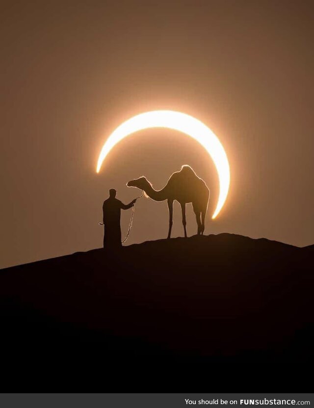 Perfectly timed photo of an eclipse around a man and a camel in by photographer Joshua