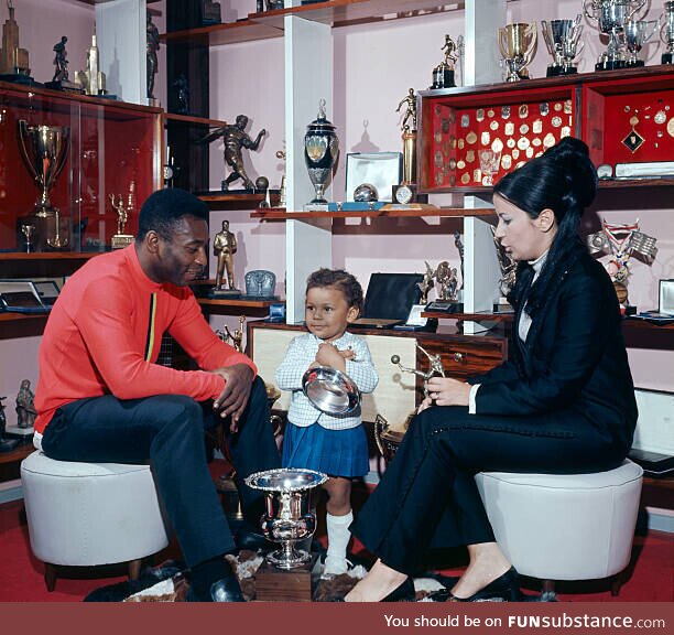 Soccer legend Pelé at home with his third wife Rosemeri, some trophies, and unidentified