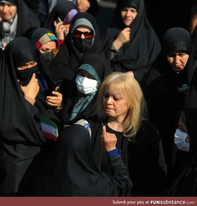 Iranian woman protesting mandatory hijab in a pro-regime rally