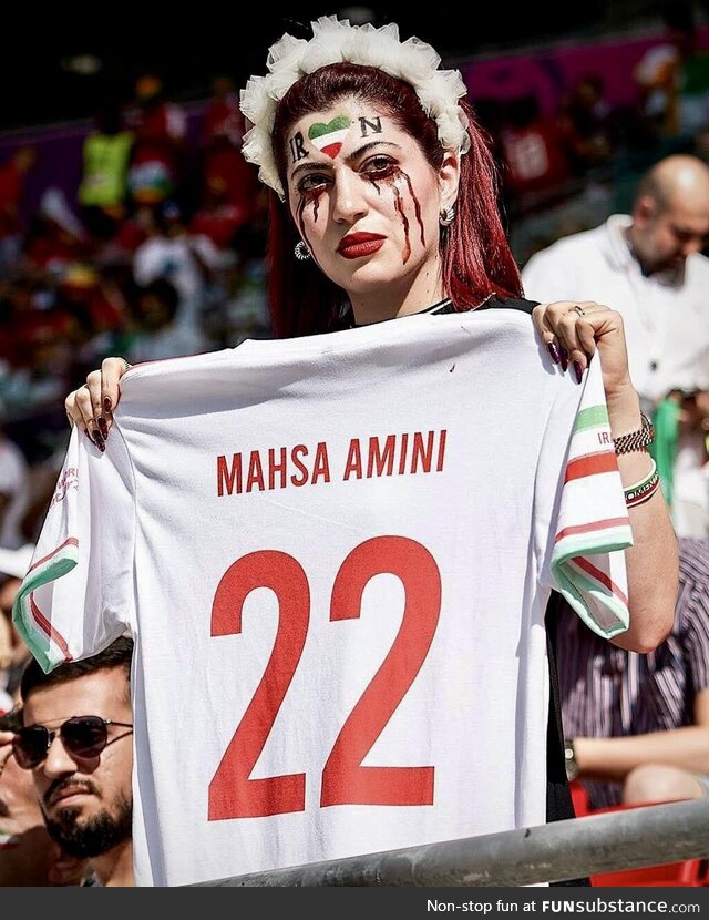 Iranian spectator showing football shirt with Mahsa Amini name written on it - Iran and