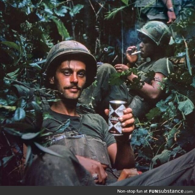 Drinking Coke while trapped in battlefield. Photo from 1970