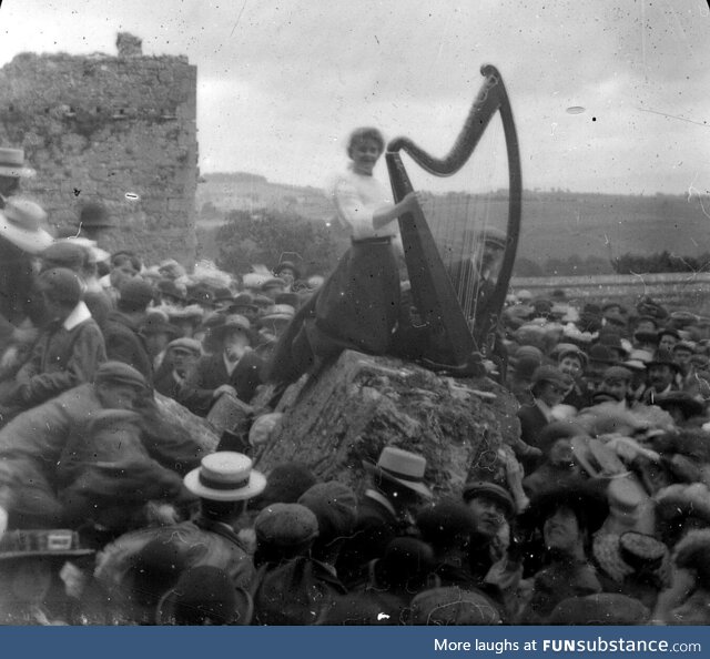 A woman playing a Harp (the symbol of Ireland) at a Gaelic Revival event circa 1910