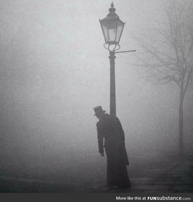 A drunk man in a top hat clings to a lamp-post in London, 1934 Photo is by Bill Brandt