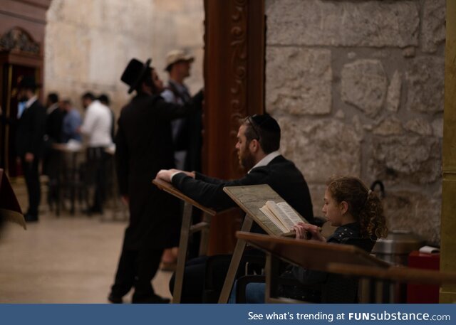 A man praying with his daughter at the synagogue of the Western Wall