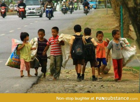 School boys passing by working boys in the Philippines