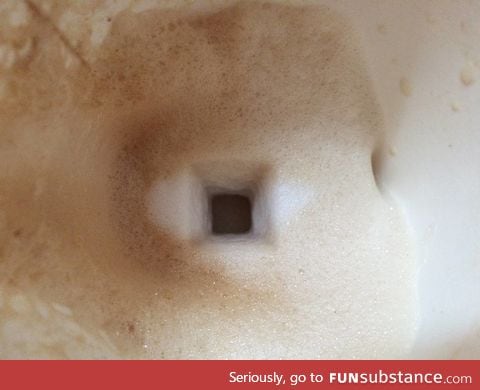 Trail of a sugar cube falling through the milk froth