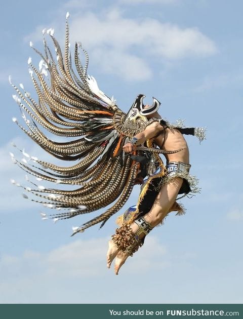 Man in traditional Aztec garb jumping