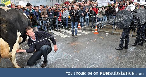 A protestor spraying milk on policemen during a protest againest falling milk prices