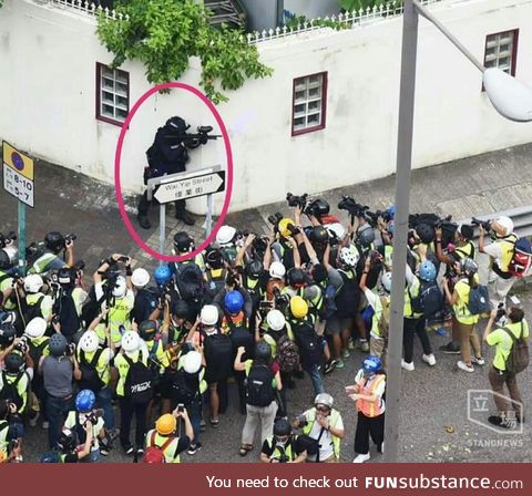 Police Officer (encircled) Surrounded by Photographers in Hong Kong