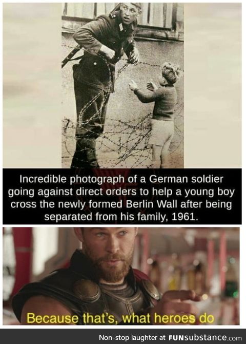 East German soldier helps a little boy sneak across the Berlin Wall, 1961