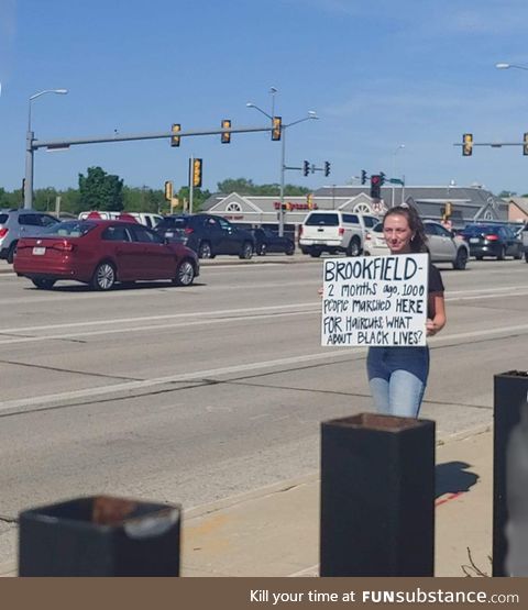 Young woman at Wisconsin protest calls out her city with this sign