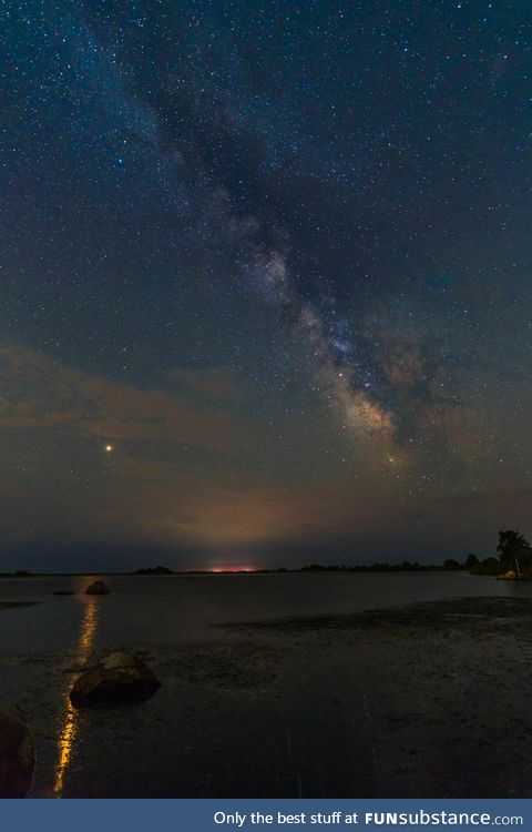 Mars casting its reflection in an ocean as it rises