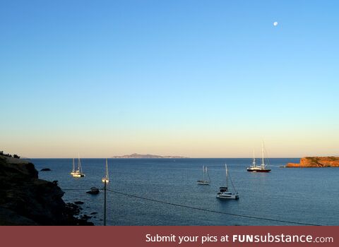 Sunrise light and moonset over the Aegean Sea in Greece