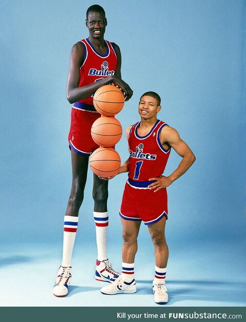 Manute Bol (7'6) standing next to his teammate, Muggsy Bogues (5'3)