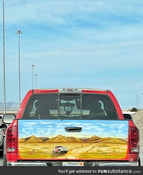 A pickup truck with something other than a decal of someone tied up on the back of it