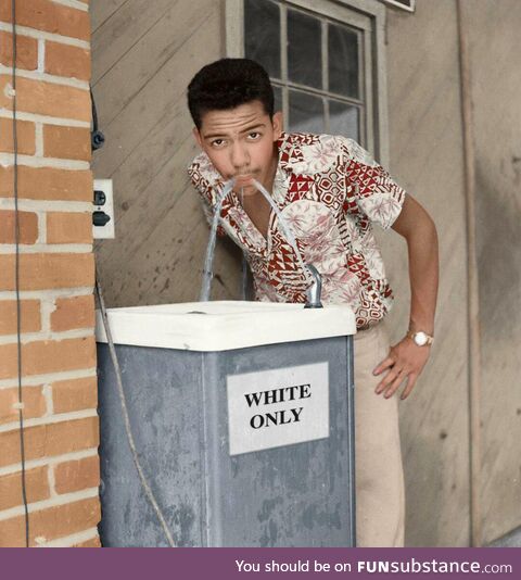 Cecil J. Williams drinking from the "White Only" fountain in 1956. -colored-