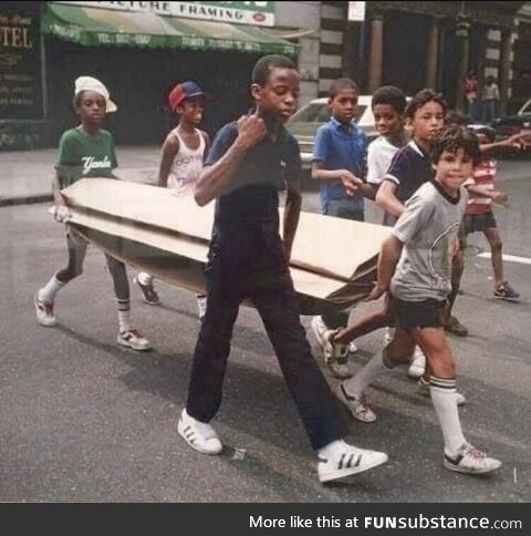 Kids carrying cardboard for breakdancing in New York City (1983)