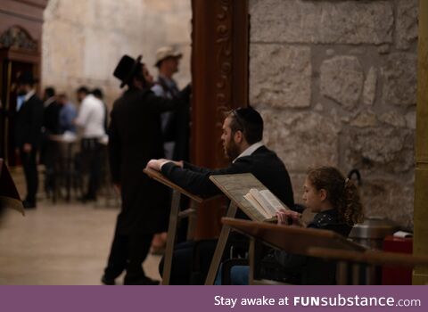 A man praying with his daughter at the synagogue of the Western Wall