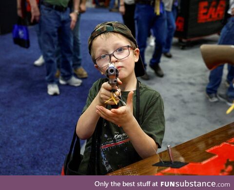 A 6-year-old from Indiana trying out a gun during the NRA's annual convention in 2023